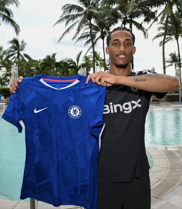 João Pedro holding a blue Chelsea football shirt in 2025