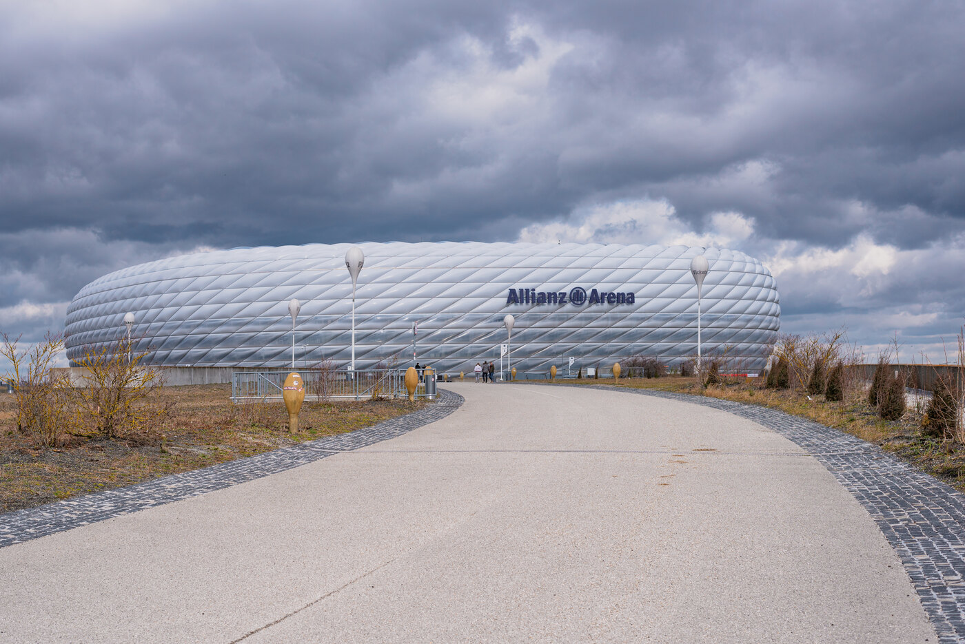 The Allianz Arena football stadium in Munich under a cloudy sky