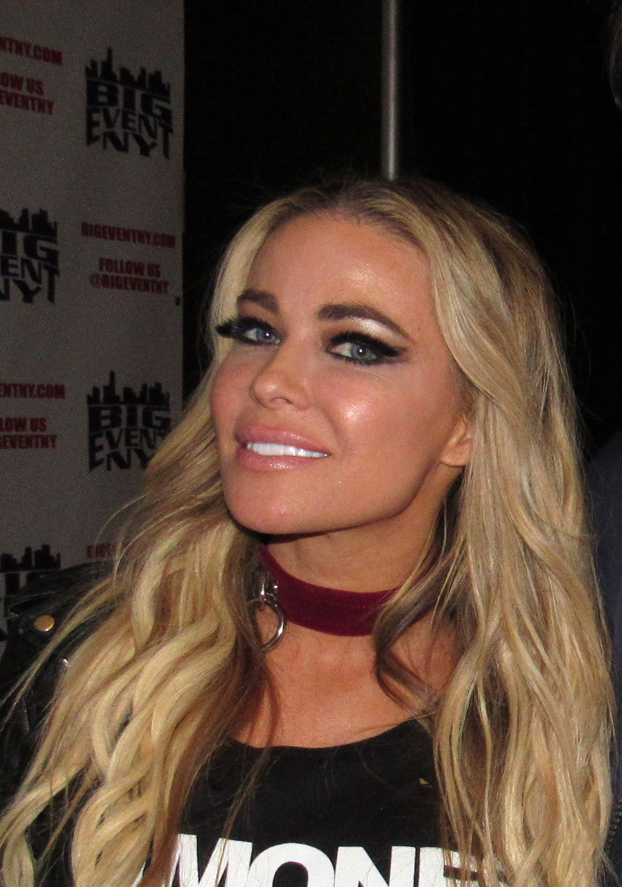 Carmen Electra posing on a red carpet in a black evening dress