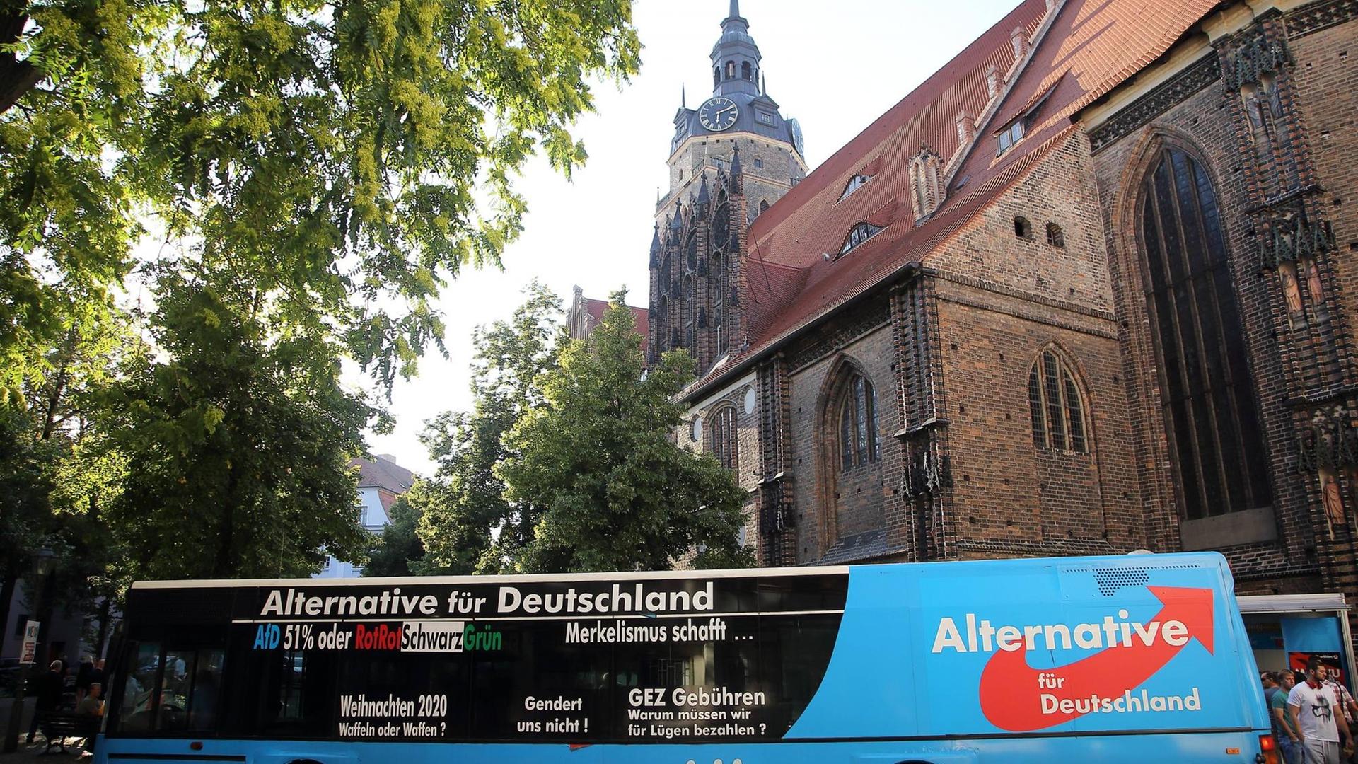 A political campaign bus parked near a historic German church
