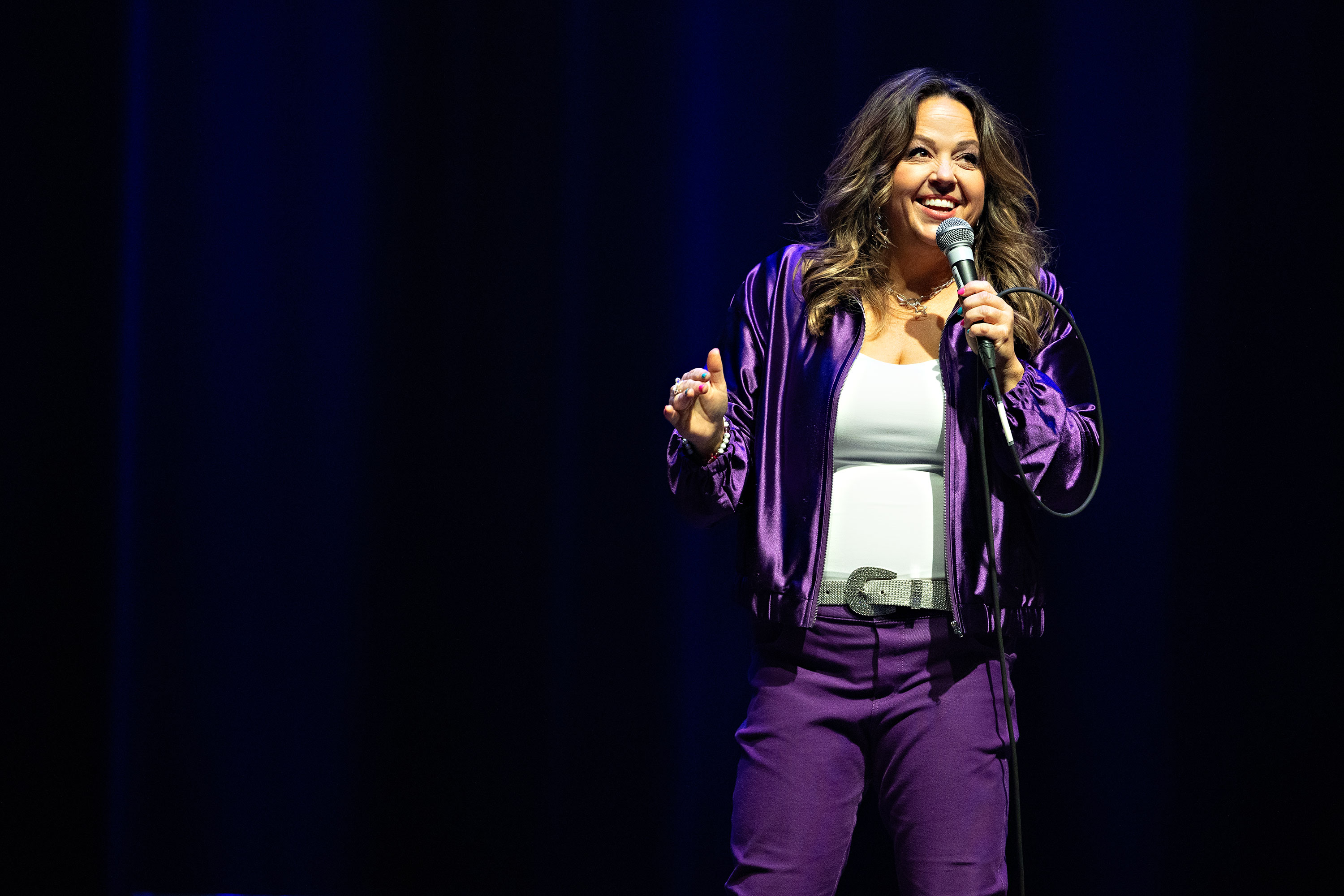 Gen X comedian and creator Kelly Manno smiling in an official promotional photograph