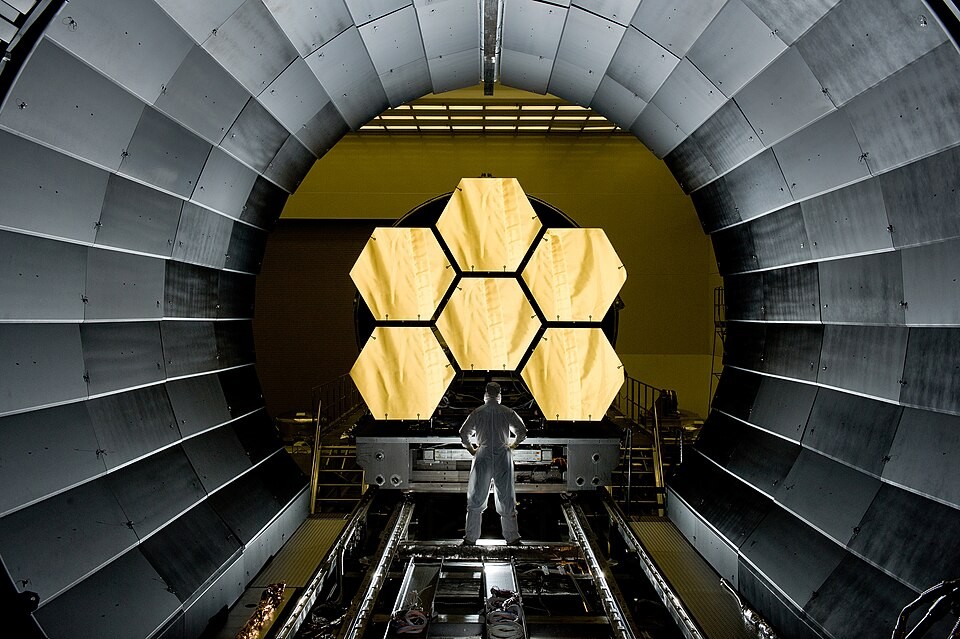 NASA engineer Ernie Wright beside six Webb mirror segments in April 2011