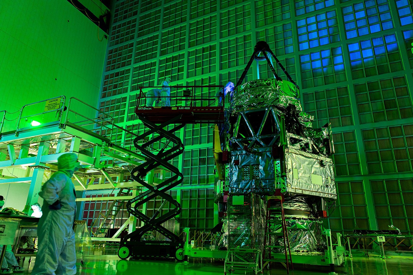 Technicians inspect the Roman Space Telescope primary mirror in a cleanroom