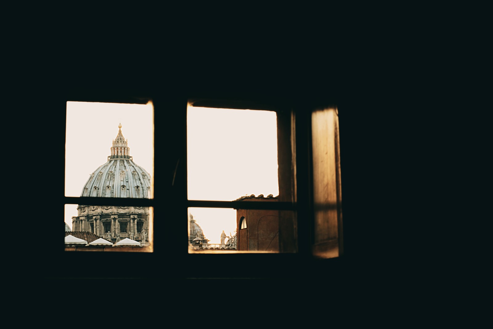 St. Peter’s Basilica dome seen through a dark window frame