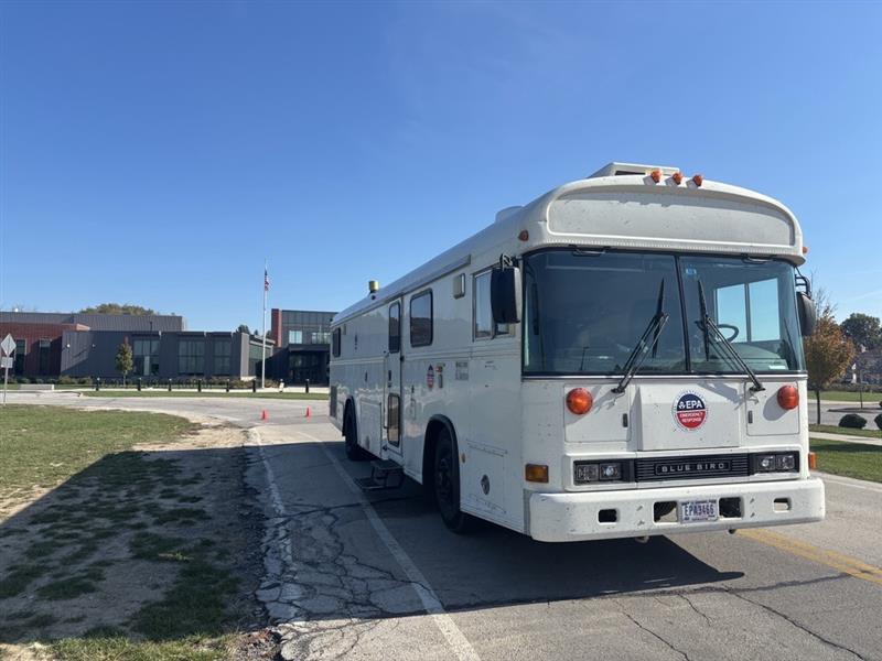 EPA’s white TAGA mobile air-monitoring bus on a Toledo street, with an EPA emblem on the front and a building behind it