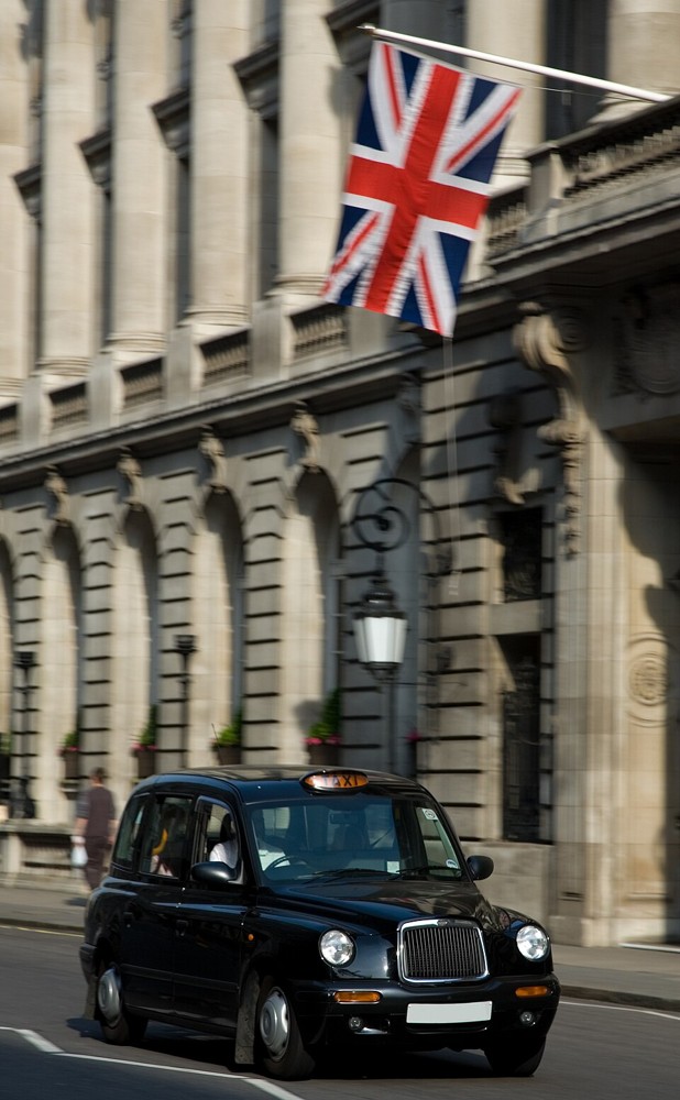 A black London taxi passing a hotel in April 2007